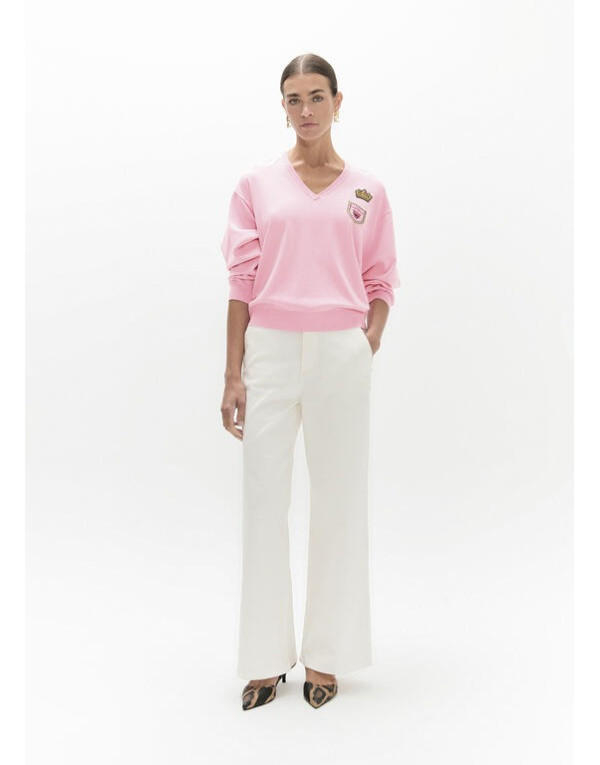 Pull rose à patches Lola Casademunt porté avec pantalon blanc